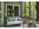 Relaxing screened porch with swing, wicker furniture, and view of backyard at 9032 Selborne Ln, Chattahoochee Hills, GA 30268