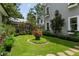 Beautifully landscaped yard featuring a circular garden bed, manicured hedges, and stone pathways around the home at 9032 Selborne Ln, Chattahoochee Hills, GA 30268