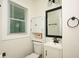 Small bathroom with white vanity, toilet, and black framed mirror at 679 Montevista St, Atlanta, GA 30310