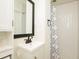 Clean bathroom with white vanity, shower, and patterned curtain at 679 Montevista St, Atlanta, GA 30310