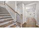 Light oak staircase with black metal balusters and view of living area at 718 Smokey Quartz Way, Kennesaw, GA 30144