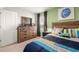 Bedroom with wood dresser and colorful striped comforter at 279 Friendship Oak Way, Hampton, GA 30228