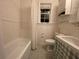 Clean bathroom with a tub, toilet and pedestal sink at 51 Peachtree Memorial Nw Dr # 4, Atlanta, GA 30309