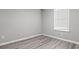 Simple bedroom with window, grey walls, and wood-look flooring at 2793 Keystone Ave, Lithonia, GA 30058