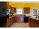 Kitchen with dark wood cabinets, granite counters and yellow walls at 4050 Old Fairburn Rd, Atlanta, GA 30349