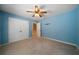 Light blue bedroom with ceiling fan and double doors to closet at 12 Spruce Ne St, White, GA 30184