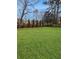 Green backyard featuring a well-manicured lawn, mature trees, and a wooden fence at 2571 Sharondale Ne Dr, Atlanta, GA 30305