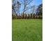 Large grassy backyard featuring mature landscaping and a wood fence at 2571 Sharondale Ne Dr, Atlanta, GA 30305