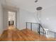 Light-filled upper hallway with hardwood floors, modern chandelier, and metal railing at 2571 Sharondale Ne Dr, Atlanta, GA 30305