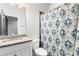 Clean bathroom with granite countertop, shower, and patterned curtain at 164A Goshen Ln, Woodstock, GA 30188