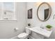 Stylish powder room with pedestal sink and elegant mirror at 164 Goshen Ln, Woodstock, GA 30188