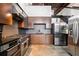 Modern kitchen with wood cabinetry, stainless steel appliances, and unique open staircase at 170 Boulevard Se # E411, Atlanta, GA 30312