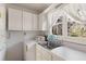 Bright laundry room with window, sink, and white cabinets at 4750 Rebel Trl, Atlanta, GA 30327