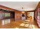 Hardwood floor living room with wood paneling and views to kitchen at 4750 Rebel Trl, Atlanta, GA 30327