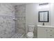 Stylish bathroom features a walk-in shower with decorative tiles, a modern vanity, and sleek fixtures at 204 Elm St, Palmetto, GA 30268