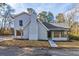 Charming exterior view of a home featuring a white brick facade and covered front porch with a landscaped yard at 204 Elm St, Palmetto, GA 30268