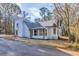Charming home with a covered porch and painted white brick foundation, surrounded by mature trees at 204 Elm St, Palmetto, GA 30268