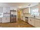 Well-designed kitchen featuring stainless steel appliances, light cabinets, and dark hardware and hardwood flooring at 204 Elm St, Palmetto, GA 30268