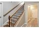 Staircase with wood railing and metal spindles, leading to a light-filled hallway at 2165 Parkview Nw Run, Atlanta, GA 30318