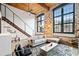 Living room with large windows, exposed brick, and modern furnishings with wood ceiling at 170 Boulevard Se # H412, Atlanta, GA 30312