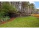 Landscaped backyard with retaining wall and grass at 3012 Lexington Ave, Woodstock, GA 30189