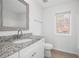 Clean bathroom featuring granite countertop vanity and a window at 3012 Lexington Ave, Woodstock, GA 30189