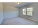 Well-lit bedroom with carpet and large windows at 225 Chiswick Loop, Stockbridge, GA 30281