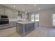 Modern kitchen with gray cabinets, quartz countertops, and island at 225 Chiswick Loop, Stockbridge, GA 30281