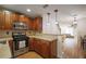 Open kitchen features stainless steel appliances and wood cabinetry at 6711 Witherington Ct, Norcross, GA 30093