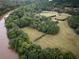Expansive aerial view showcasing the property's lush greenery, river access, and serene pastures at 75 Rivercreek Xing, Kingston, GA 30145