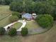 Aerial view of a house on a large lot with a long driveway and trees at 75 Rivercreek Xing, Kingston, GA 30145