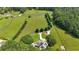 Breathtaking aerial view of the property showcasing its expansive green fields and wooded areas at 75 Rivercreek Xing, Kingston, GA 30145