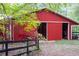 Red barn with open sliding doors and black fence at 75 Rivercreek Xing, Kingston, GA 30145