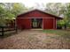 Large red barn featuring a fenced pasture, suitable for various uses at 75 Rivercreek Xing, Kingston, GA 30145