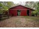 Red barn with sliding doors and adjacent fence at 75 Rivercreek Xing, Kingston, GA 30145