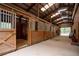 Indoor horse stables showcasing multiple stalls with wooden doors and metal bars at 75 Rivercreek Xing, Kingston, GA 30145