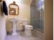 Bathroom featuring a pedestal sink, toilet, and glass shower with gold trim at 75 Rivercreek Xing, Kingston, GA 30145