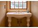 Charming bathroom featuring a pedestal sink with gold fixtures and a view from the window at 75 Rivercreek Xing, Kingston, GA 30145