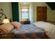 Comfortable bedroom features quilt bed, lamp, and decorative window at 75 Rivercreek Xing, Kingston, GA 30145