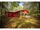 Unique exterior of home blending stone and wood with multiple windows and outdoor decking in a wooded landscape at 75 Rivercreek Xing, Kingston, GA 30145