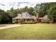 Brick home with a large front porch and landscaped lawn at 75 Rivercreek Xing, Kingston, GA 30145