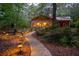 Charming home exterior at night with illuminated walkway and landscape lighting, adding warmth and curb appeal at 75 Rivercreek Xing, Kingston, GA 30145