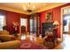Formal living room featuring a fireplace, antique furnishings, and rich red walls at 75 Rivercreek Xing, Kingston, GA 30145