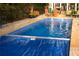 Backyard pool with a pool cover and outdoor furniture, and a black metal fence at 75 Rivercreek Xing, Kingston, GA 30145