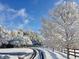 Picturesque winter scene with snow-covered trees, a winding driveway, and classic fencing at 75 Rivercreek Xing, Kingston, GA 30145