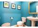 Charming powder room with pedestal sink and teal walls at 928 Buckhorn Bnd, Locust Grove, GA 30248