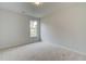 Well-lit bedroom with neutral carpeting and large window at 115 Felicity Pike, Locust Grove, GA 30248