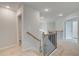 Upstairs hallway with wooden railing and neutral carpeting at 115 Felicity Pike, Locust Grove, GA 30248