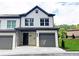 Two-story townhome with gray and white exterior, two-car garage, and landscaping at 2920 Ilir Nw Mnr, Atlanta, GA 30318