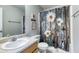 Charming bathroom features patterned shower curtain, tile floors, and vanity at 12524 Highway 36, Covington, GA 30014